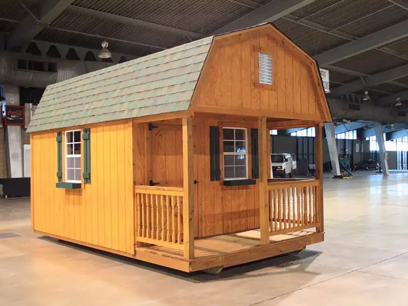 A small wooden house with a porch and windows.
