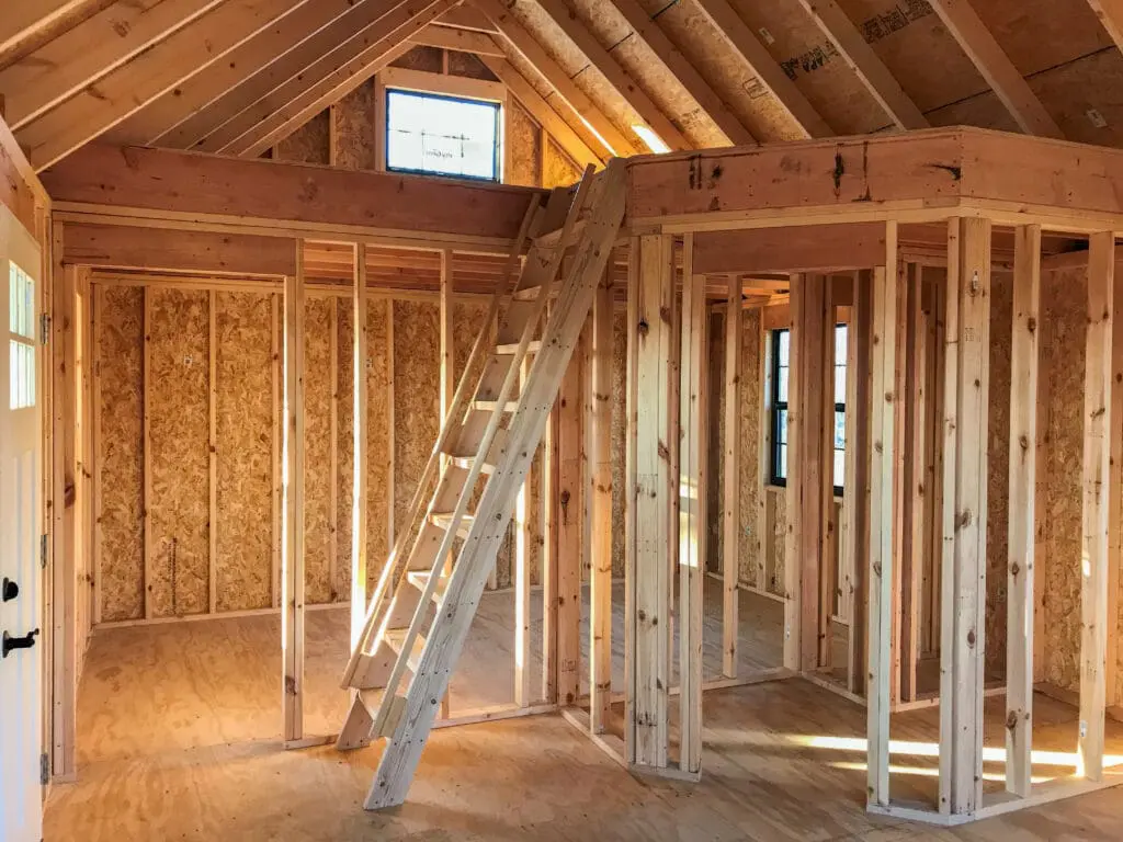 Here's an alt tag for the image: Unfinished house interior framing.